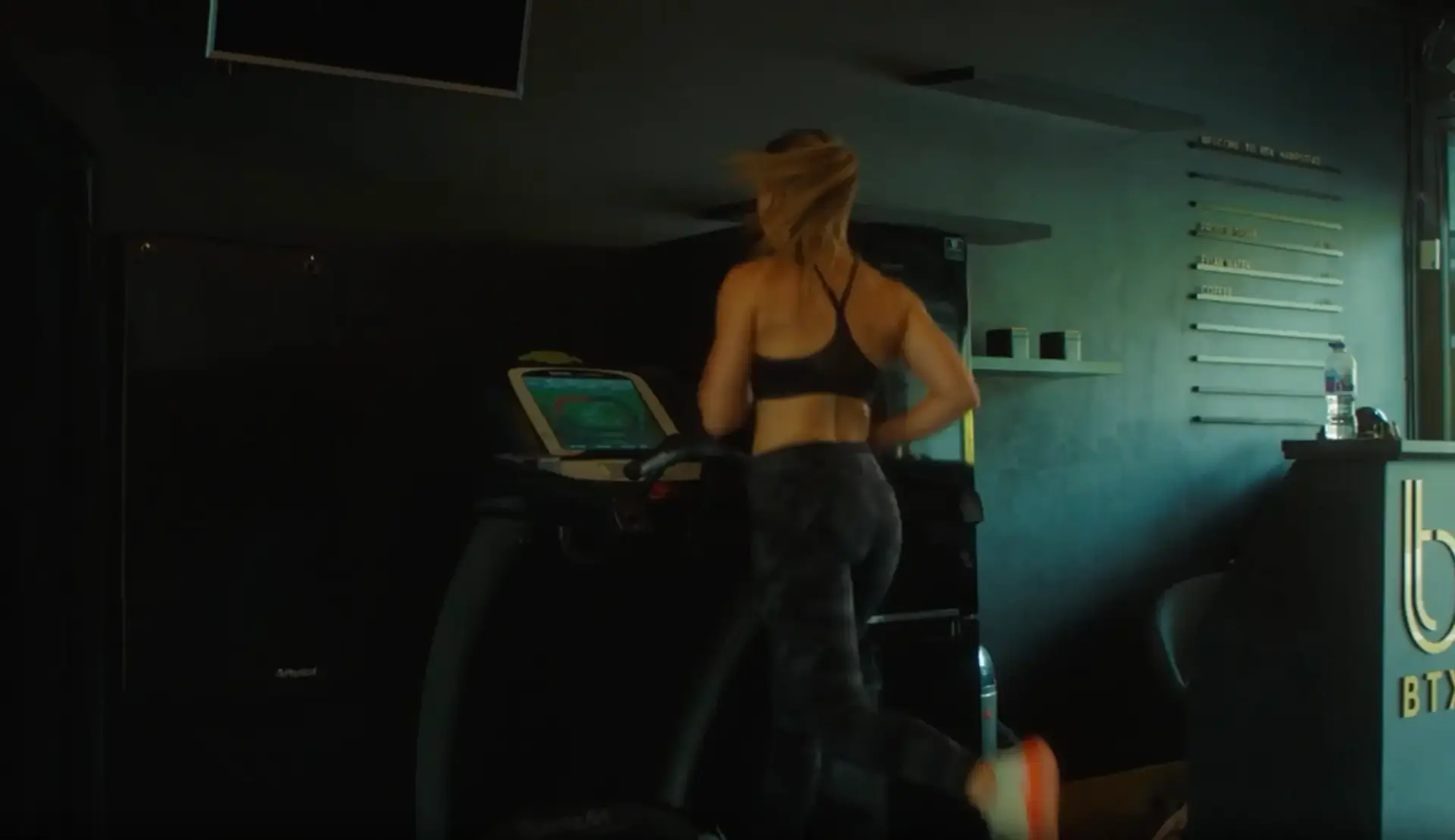 Client running on a treadmill in the dark BTX studio