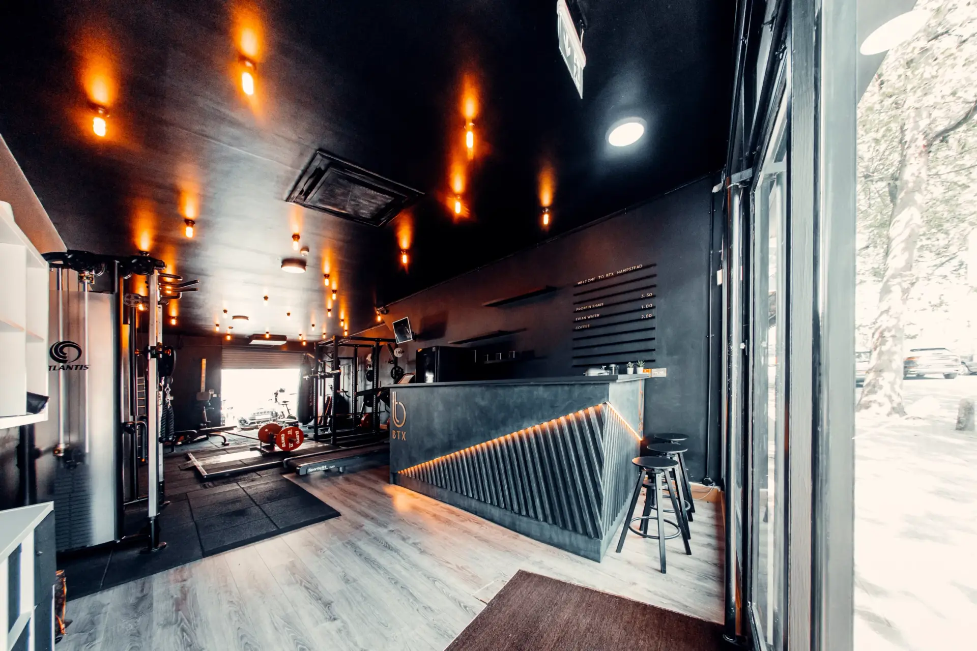 The BTX studio from the front: reception counter, warm pendant lights and the rig behind