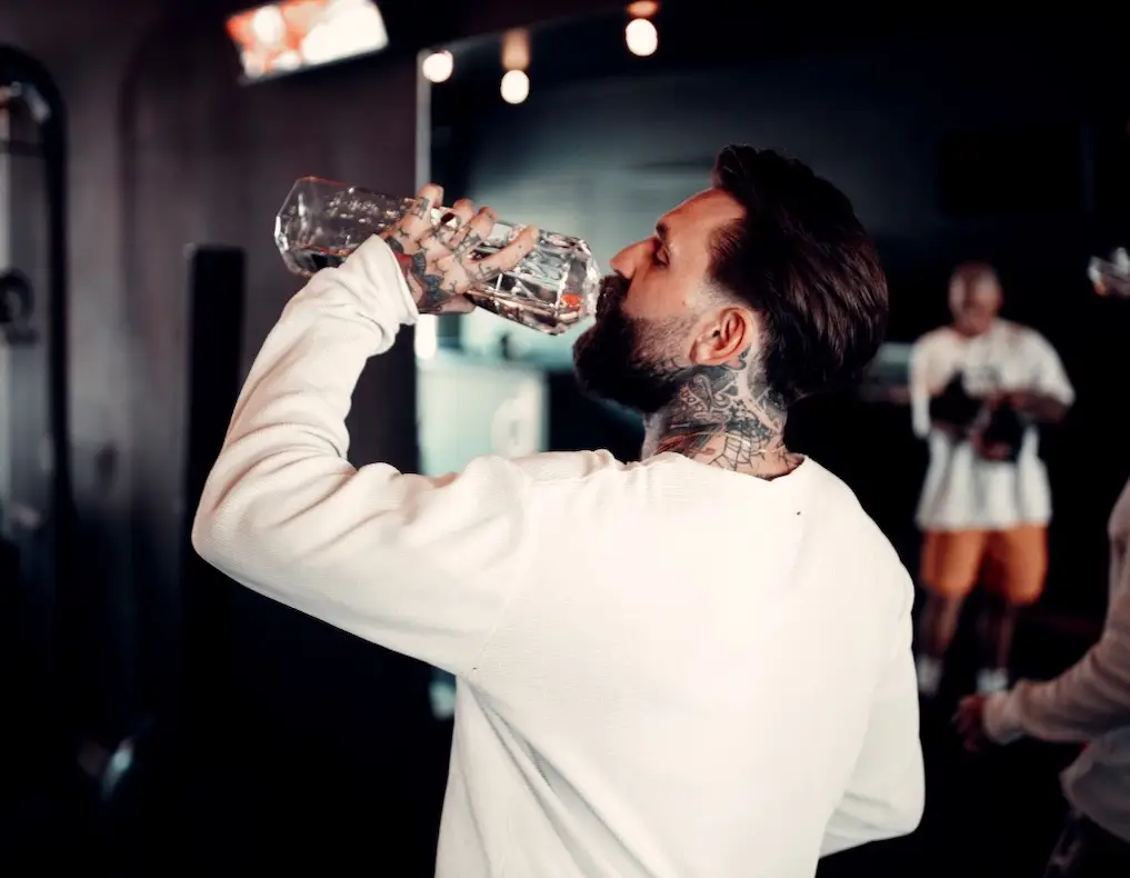 Client in a white top drinking from a shaker in the BTX studio
