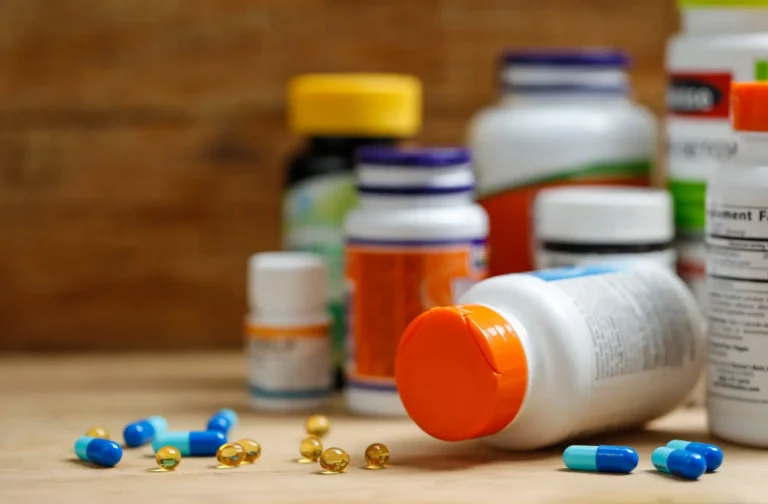 Supplement bottles and tablets on a wooden desk